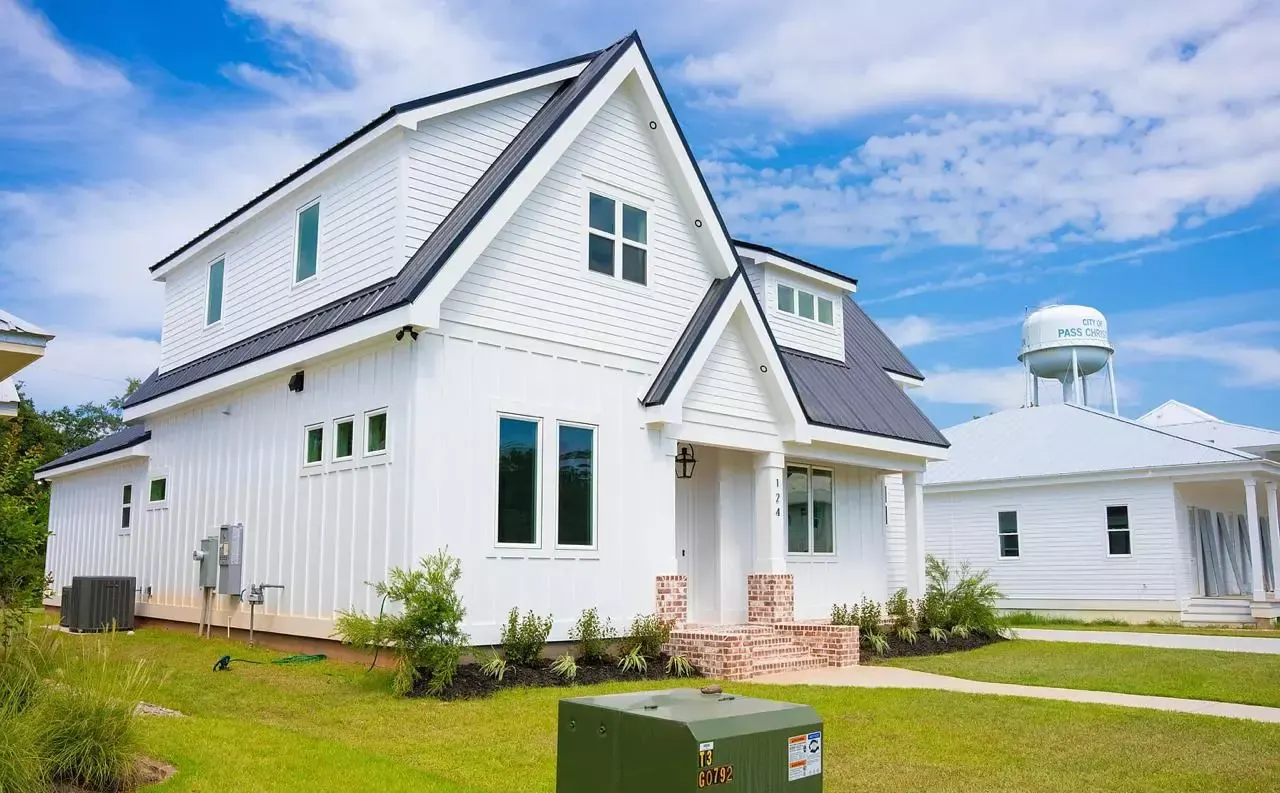 Coastal cottage custom home with white board-and-batten siding built by Supreme Contractors Group on Oaks Dr in Pass Christian, Mississippi