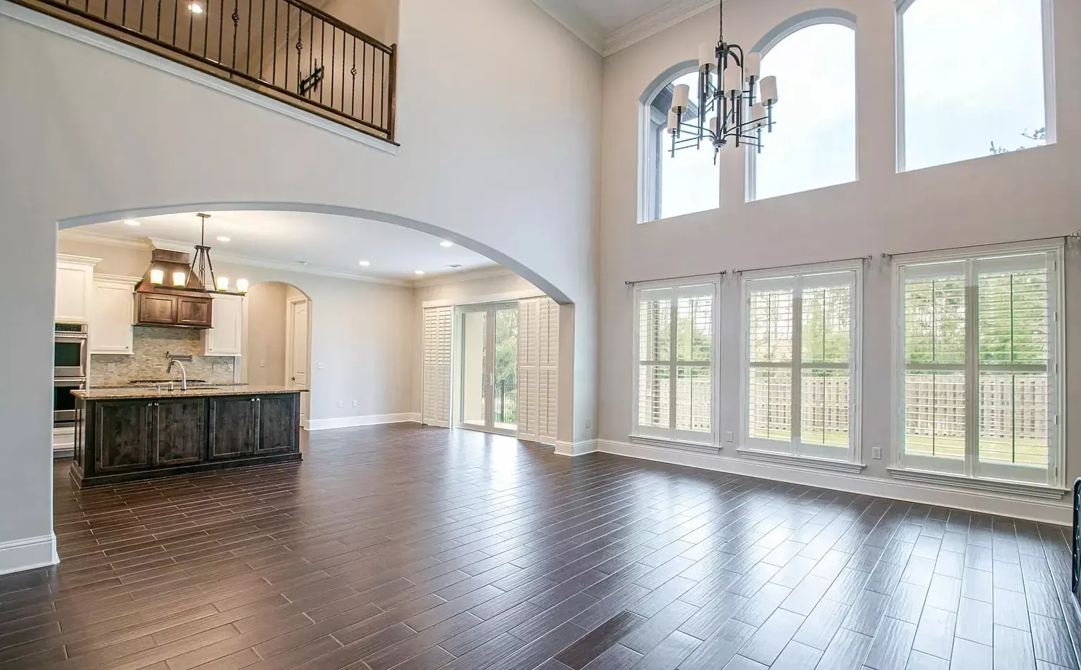 Two-story great room with arched windows in a custom home built by Supreme Contractors Group